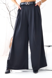 Fashion Studio Spodnie SZWEDY - czarne - Szerokie spodnie o luźniejszym kroju. Guma w pasie w tylnej części. Zakładki z przodu spodni idealnie maskują wszelkie mankamenty. Wysoki stan, który podkreśla talię. Lejący się materiał dodaje klasy całej stylizacji. Eleganckie, idealne na każdą okazję, jak i na co dzień czy do pracy. Pasek w zestawie.