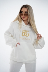 Brandenburg Couture DRES DAMSKI BG ROYAL SUEDE - biały - Komplet zamszowy BG ROYAL SUEDE w kolorze białym. Bluza kangurka z kapturem ozdobiona dużym haftowanym złotym logiem marki BG BRANDENBURG COUTURE. Spodnie posiadają gumkę w pasie. Na lewej kieszeni spodni wyhaftowane złote logo marki. Krój oversize. Ozdobne przeszycia na bluzie oraz spodniach.