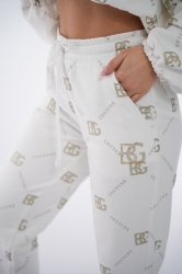 Brandenburg Couture DRES DAMSKI BG HOLO - biały - Komplet dresowy bawełniany (nieocieplany) w kolorze białym. Dres charakteryzuje się kontrastowym, przecieranym hologramem na całości w kolorze złotym. Bluza z kapturem oraz spodnie są ozdobione wyklejanymi, złotymi kryształkami w kształcie logo BG.  Komplet wykończony jest gumkami. Spodnie posiadają kieszenie oraz sznurek w pasie. Luźny krój.

Polska marka BG Brandenburg Couture.